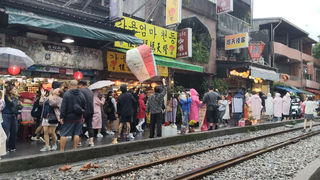 十分老街で強風にあおられたランタンを慌てて掴む店員